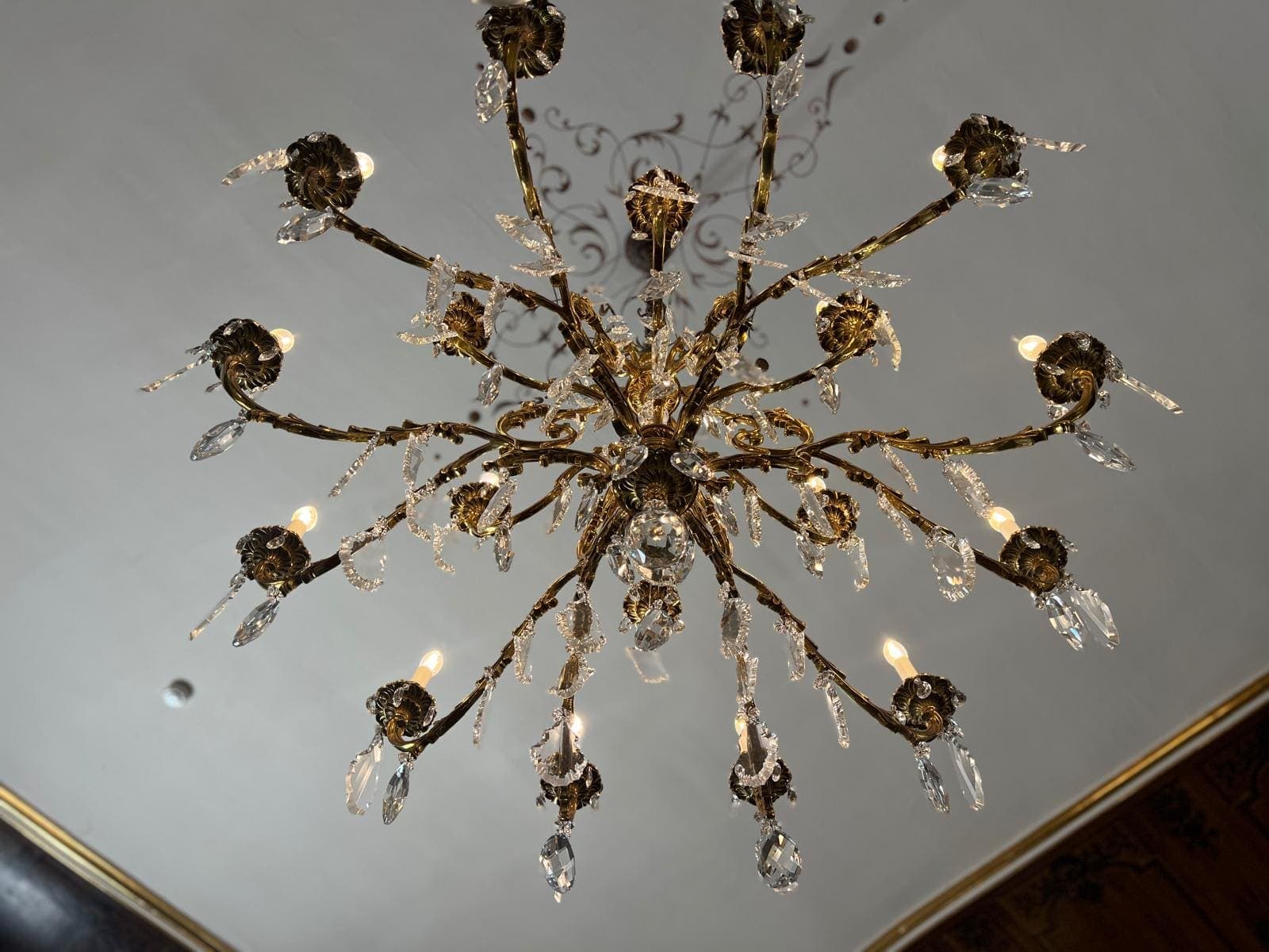 Lustre en cristal et bronze doré, vu de dessous, dans un salon de château