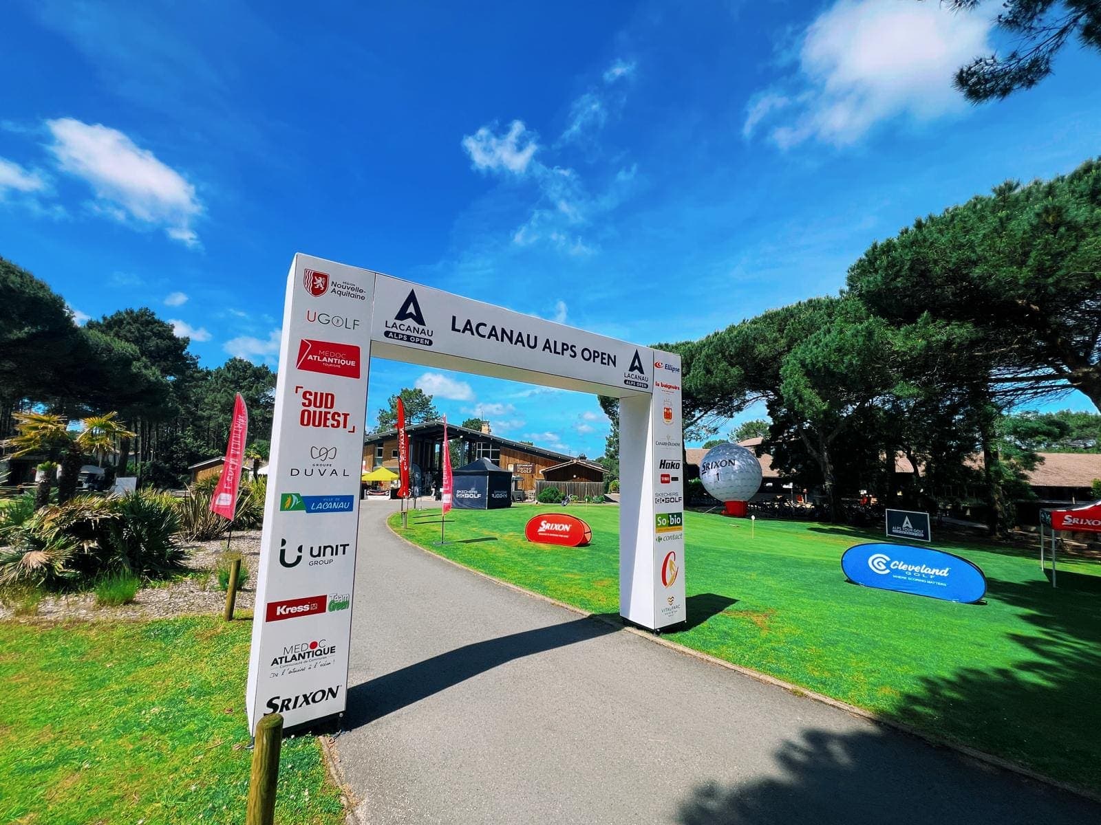 Portique d’entrée du tournoi de golf Lacanau Alps Open, sous un grand ciel bleu