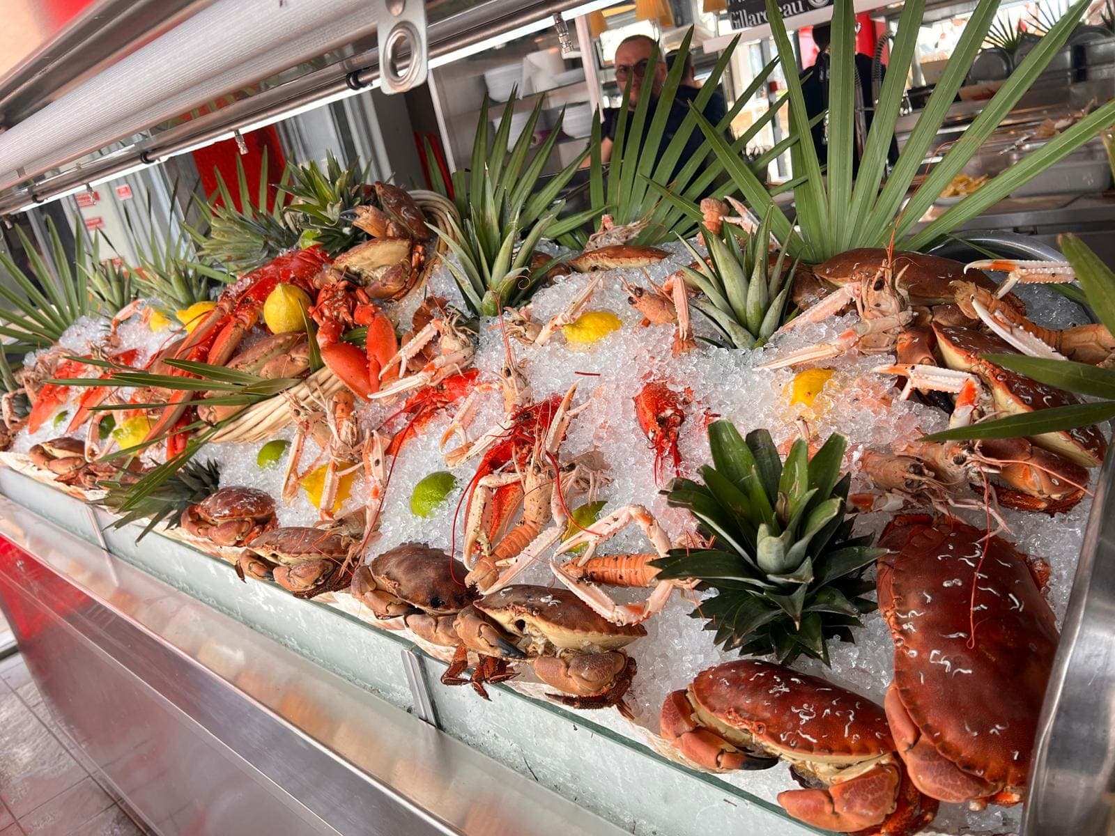 Étal de fruits de mer sur glace, crabes et langoustines décorés de feuilles de palmier